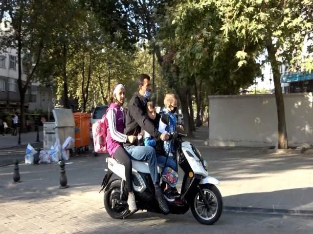 Bir motosiklette bir veli 3 öğrenci